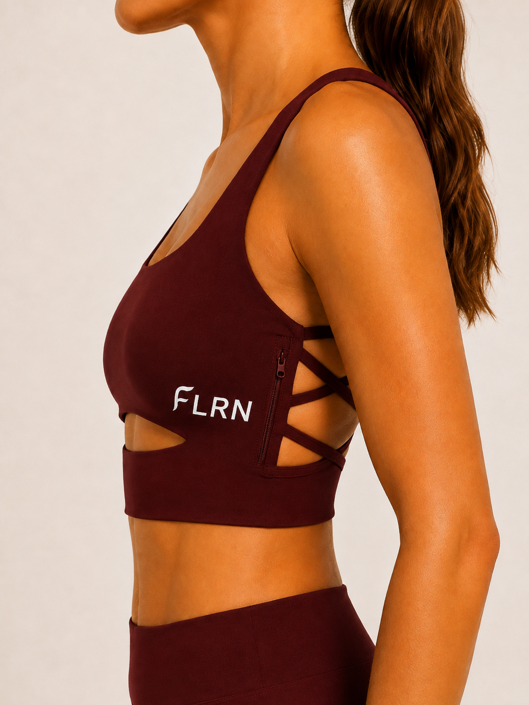 Side view of the FLRN Signature Sports Bra showing the strappy detail and side zip pocket